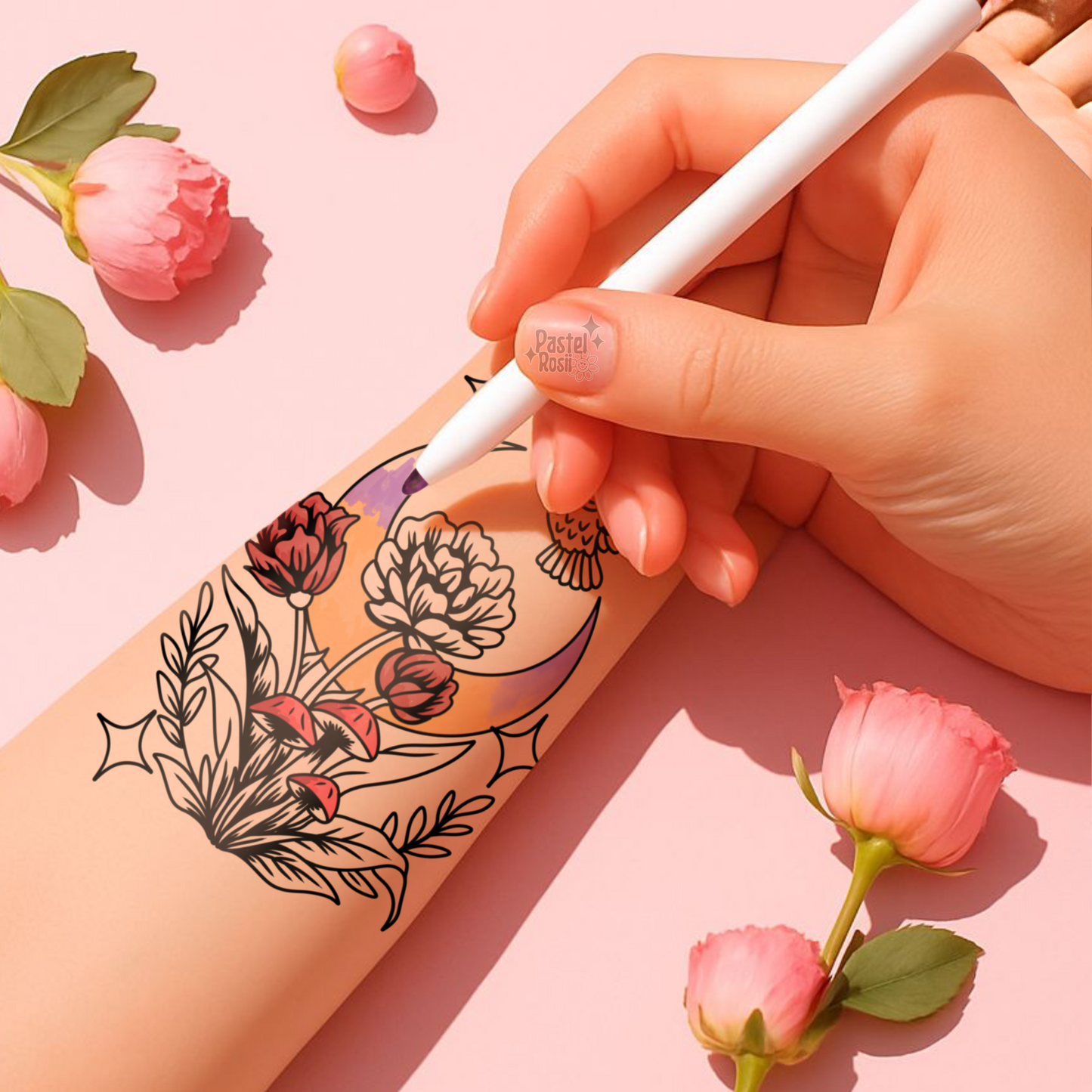 Hand holding a white pen over a floral tattoo design on skin with pink flowers and leaves around.