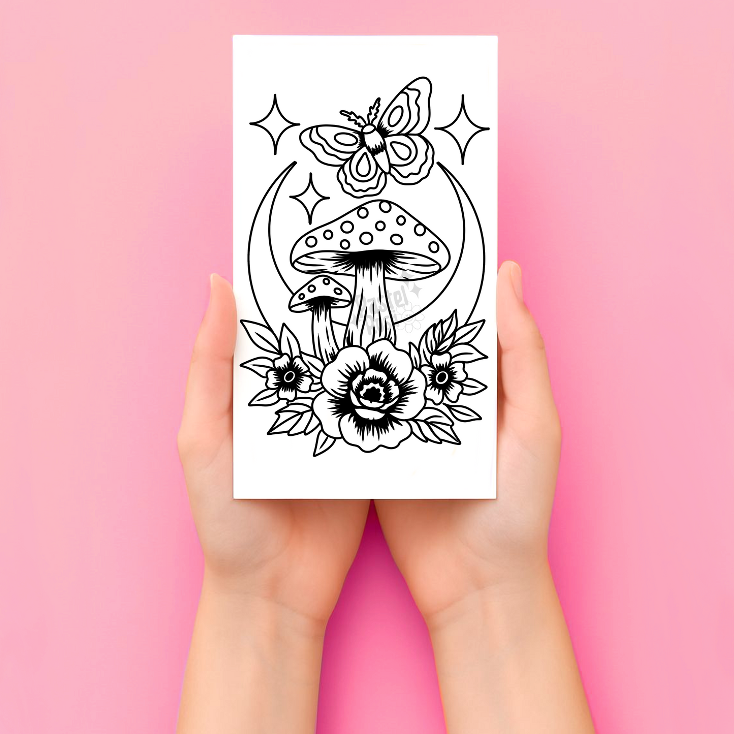 Hands holding a tattoo with black and white illustration of mushrooms and flowers on a pink background