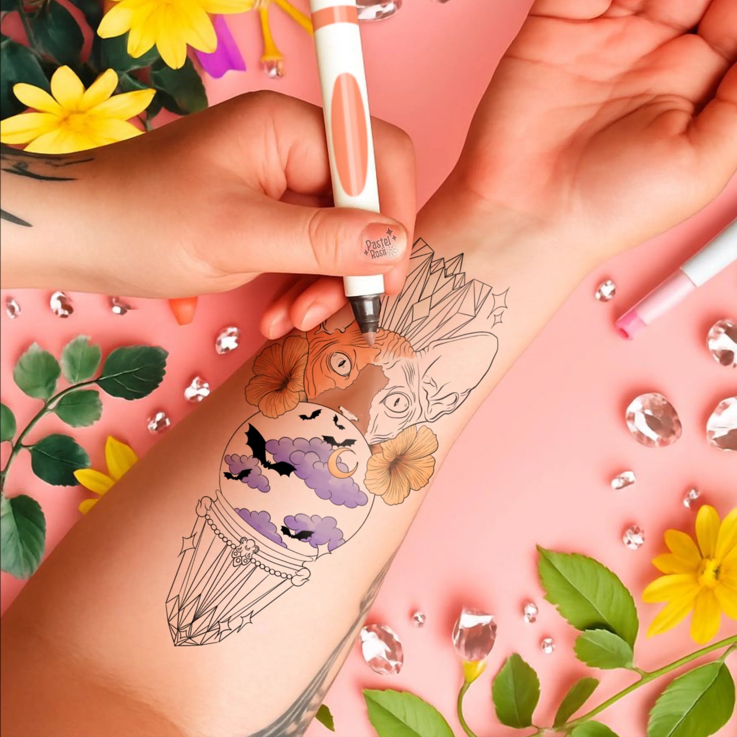 Person getting a temporary tattoo of a decorative sphynx design on their arm, with a pink background and floral elements.
