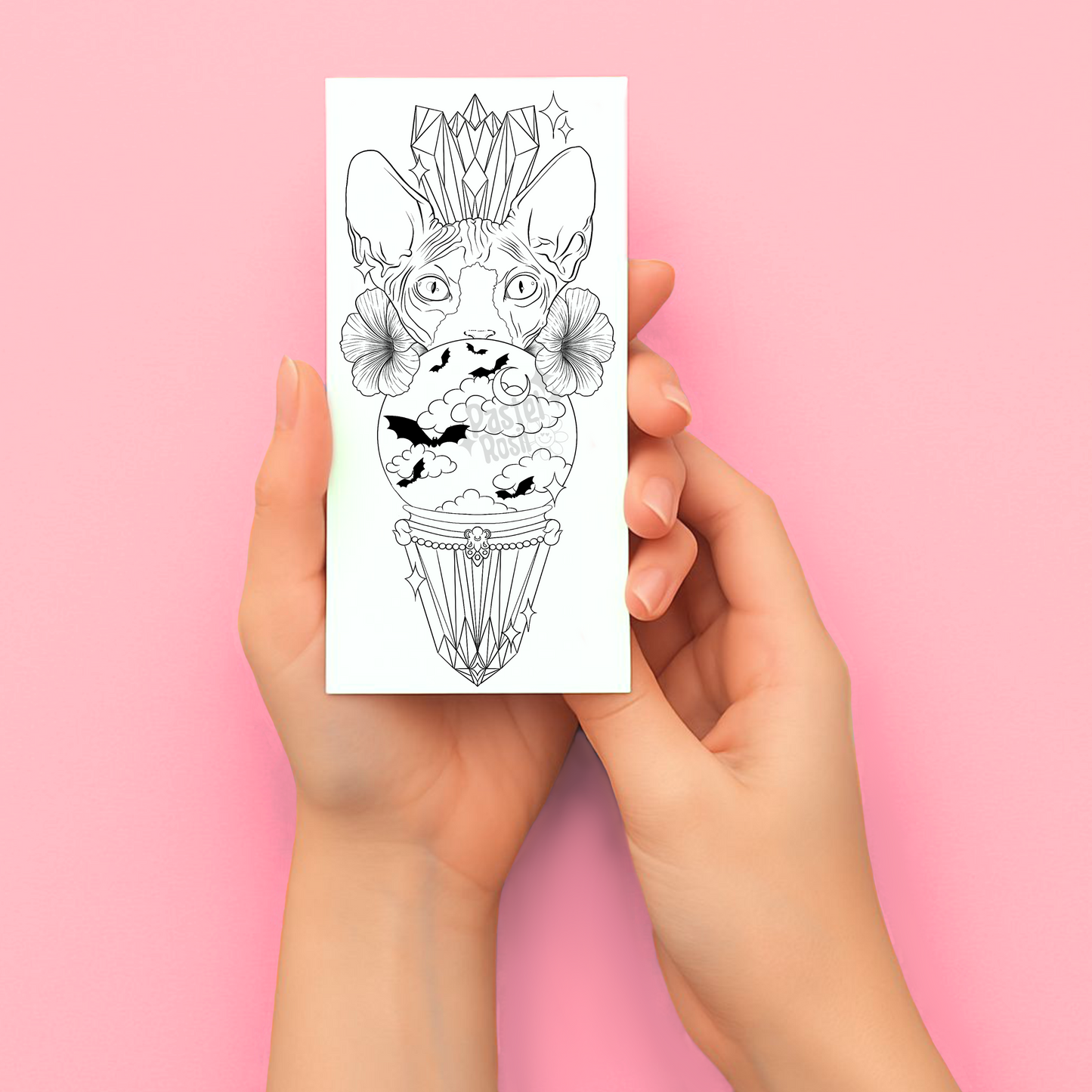 Hands holding a temporary tattoo with a black and white illustration of a cat with flowers on a pink background