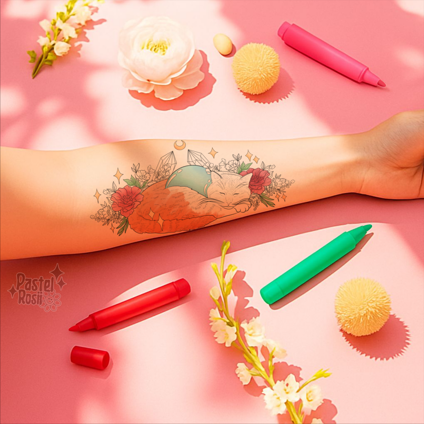 Tattoo on a arm with colorful markers and decorative items on a pink background
