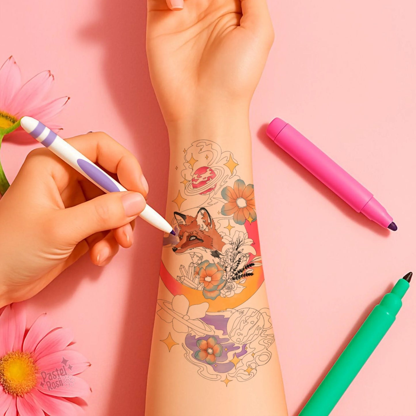 Colorful temporary tattoos being applied to a person's arm with tattoo pens on a pink background.