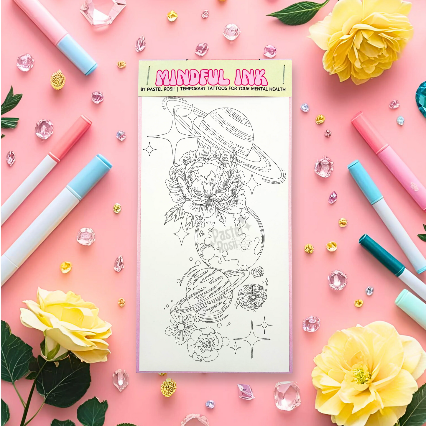 Temporary tattoo with designs on a pink background with markers and flowers