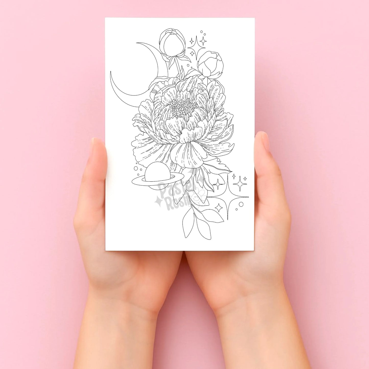 Hands holding a tattoo sheet with floral and moon design on a pink background