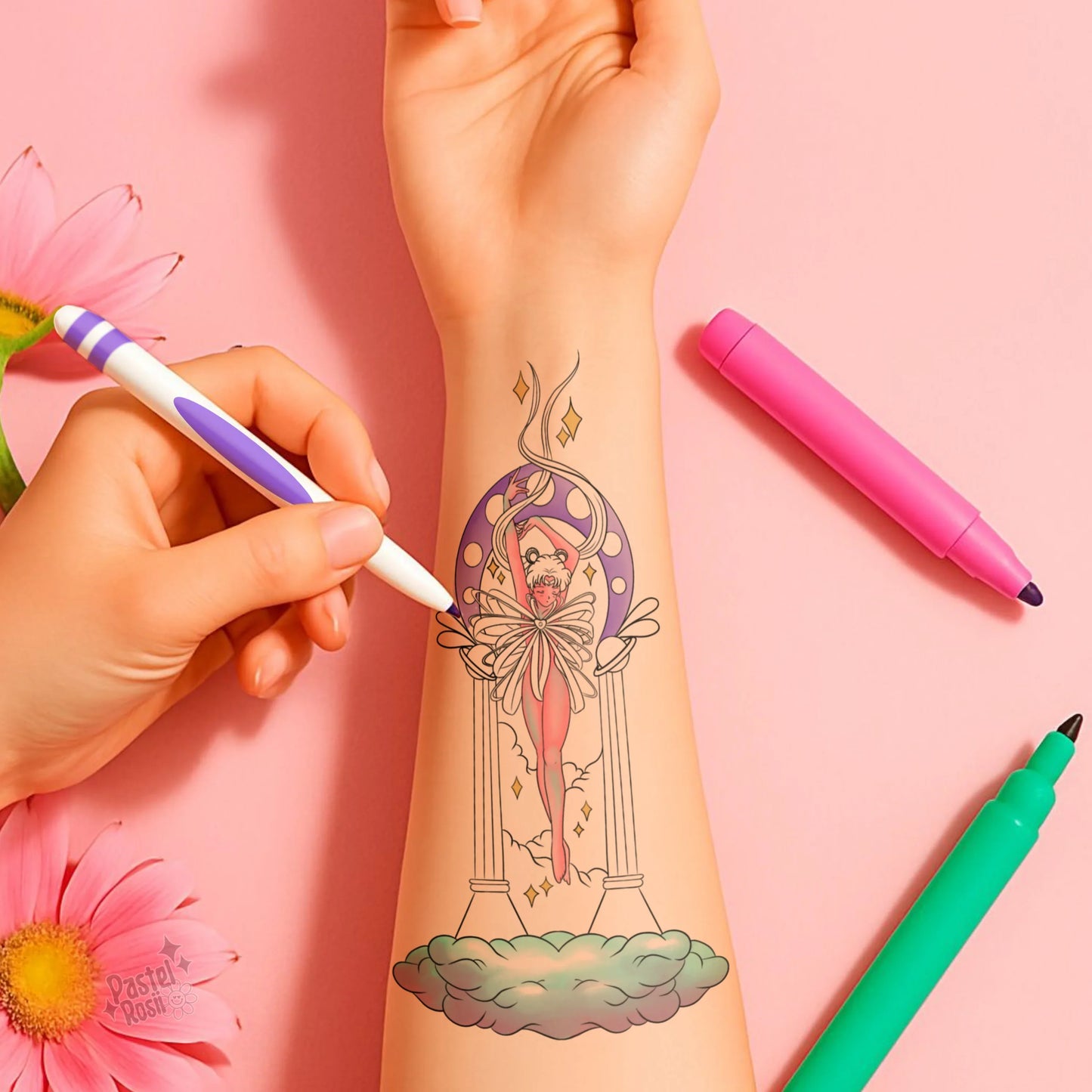 Hand applying a temporary tattoo of a woman design on a pink background with colorful pens.