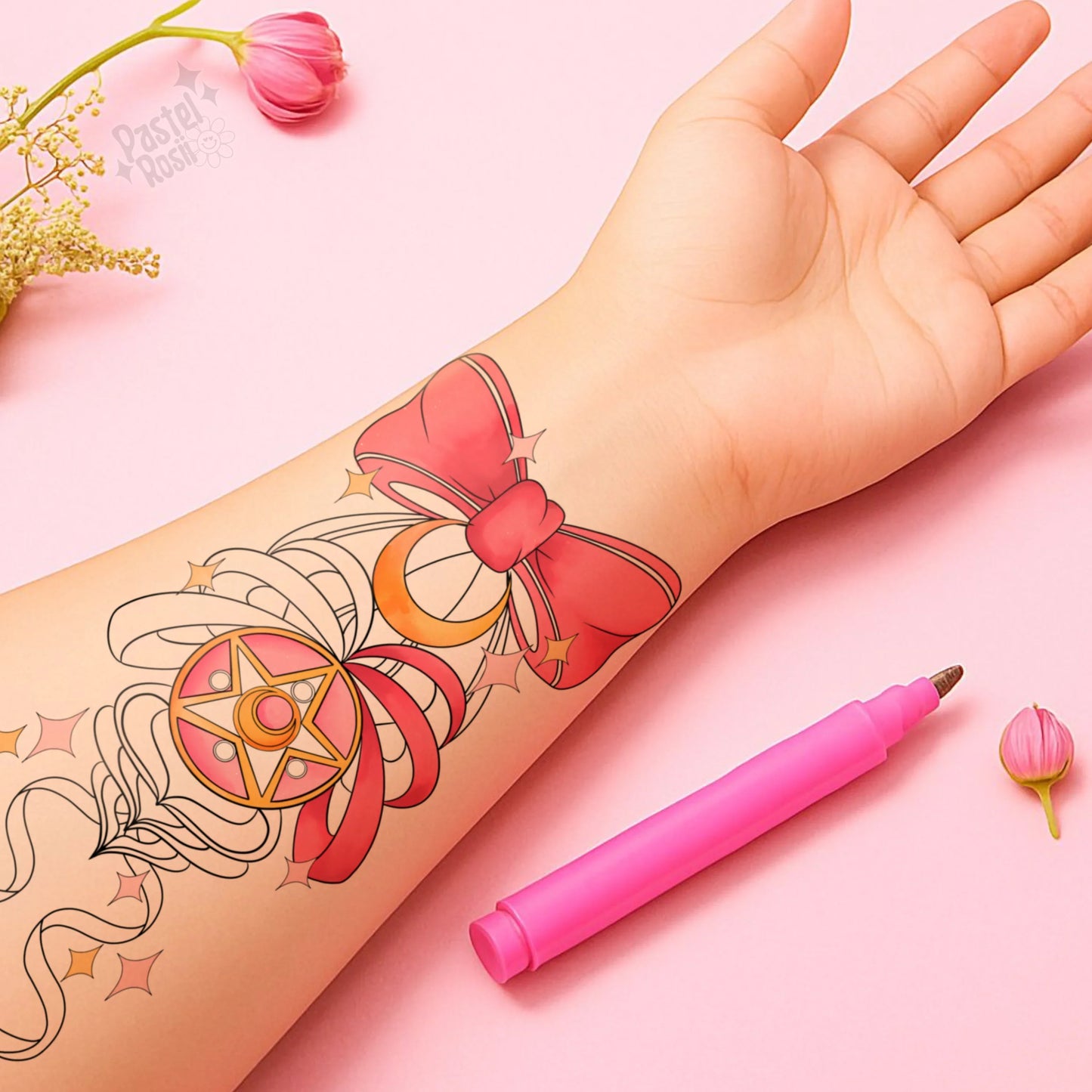 Hand with temporary tattoo of a bow and star design, pink pen, and flowers on a pink background