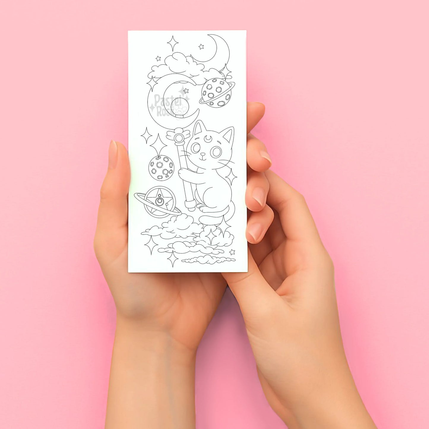 Hands holding a sheet of temporary tattoos with a cat design on a pink background