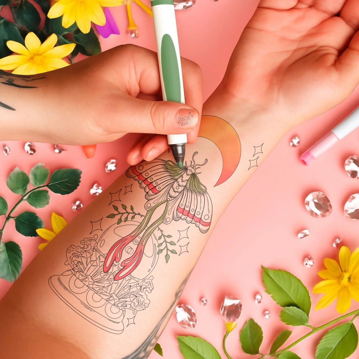 Person getting a temporary tattoo of a butterfly design on their arm with floral and decorative elements in the background.