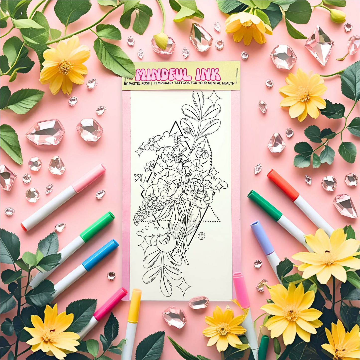 Temporary tattoo with floral design surrounded by markers, flowers, and leaves on a pink background