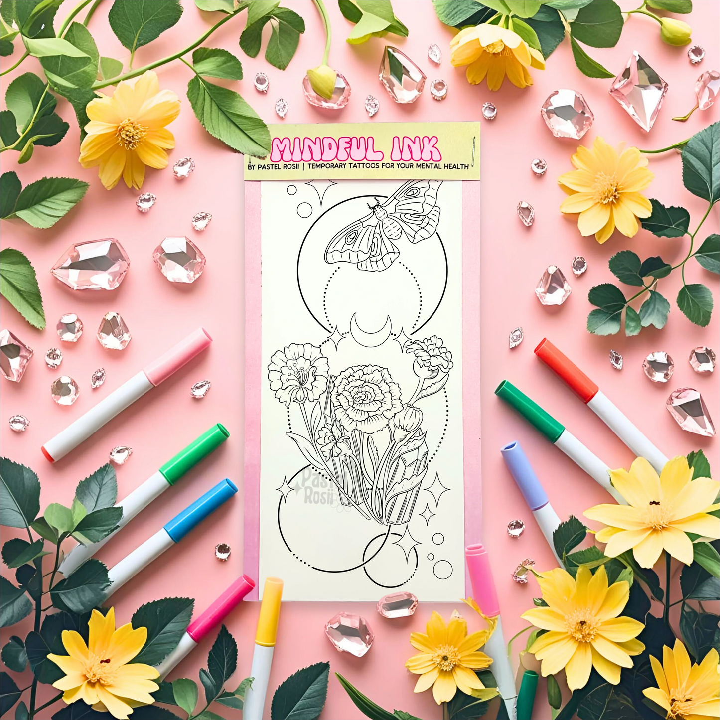 Temporary tattoo with floral designs on a pink background with markers and flowers.