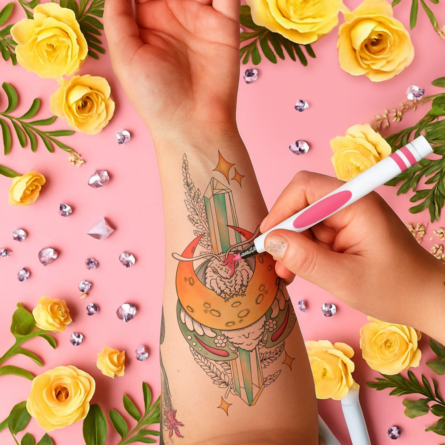 Person getting a tattoo of a colorful design on a pink background with yellow roses and decorative elements.
