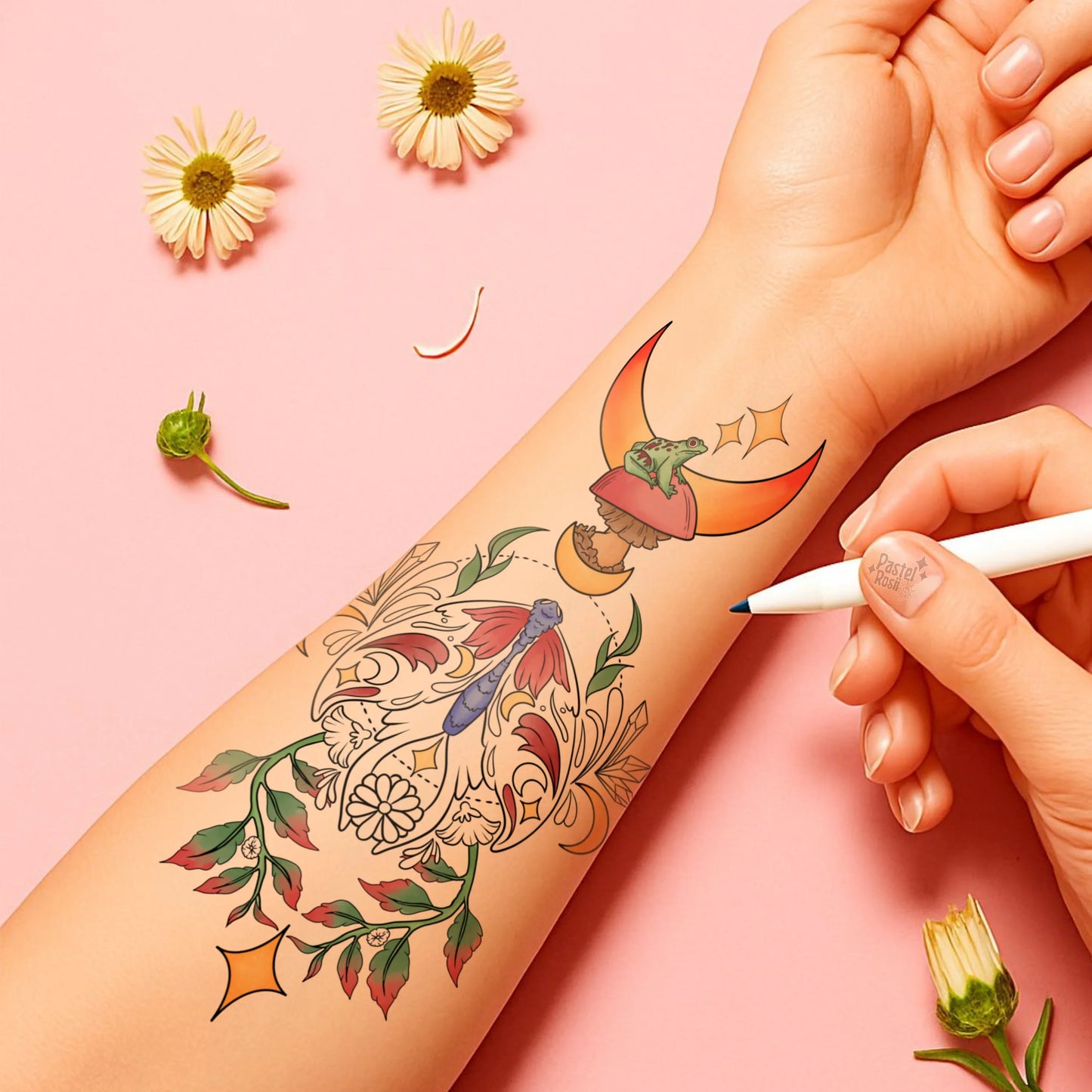 Colorful temporary tattoo being applied to a person's arm with flowers on a pink background