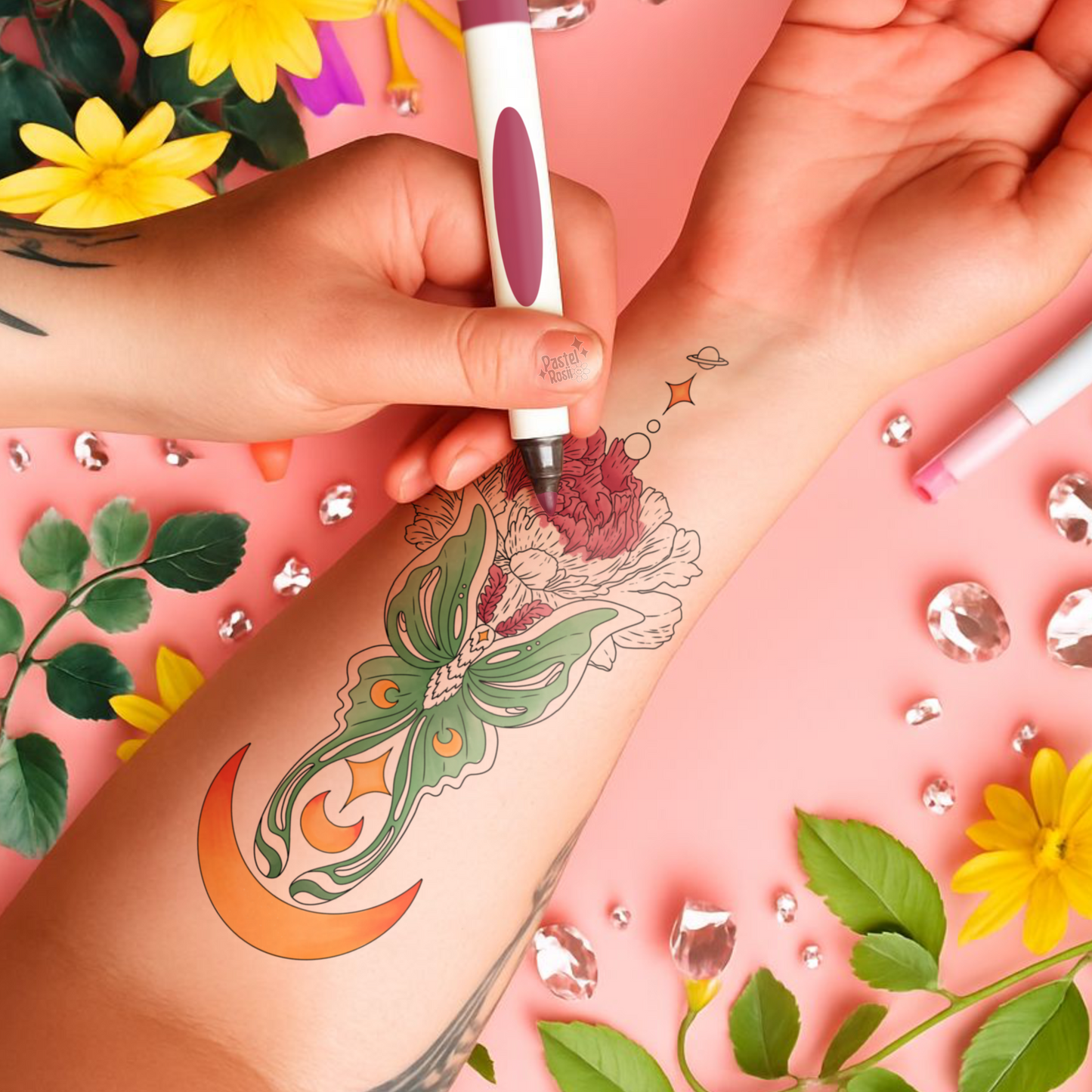 Person getting a temporary tattoo of a colorful design on their arm with a pink background and floral elements.