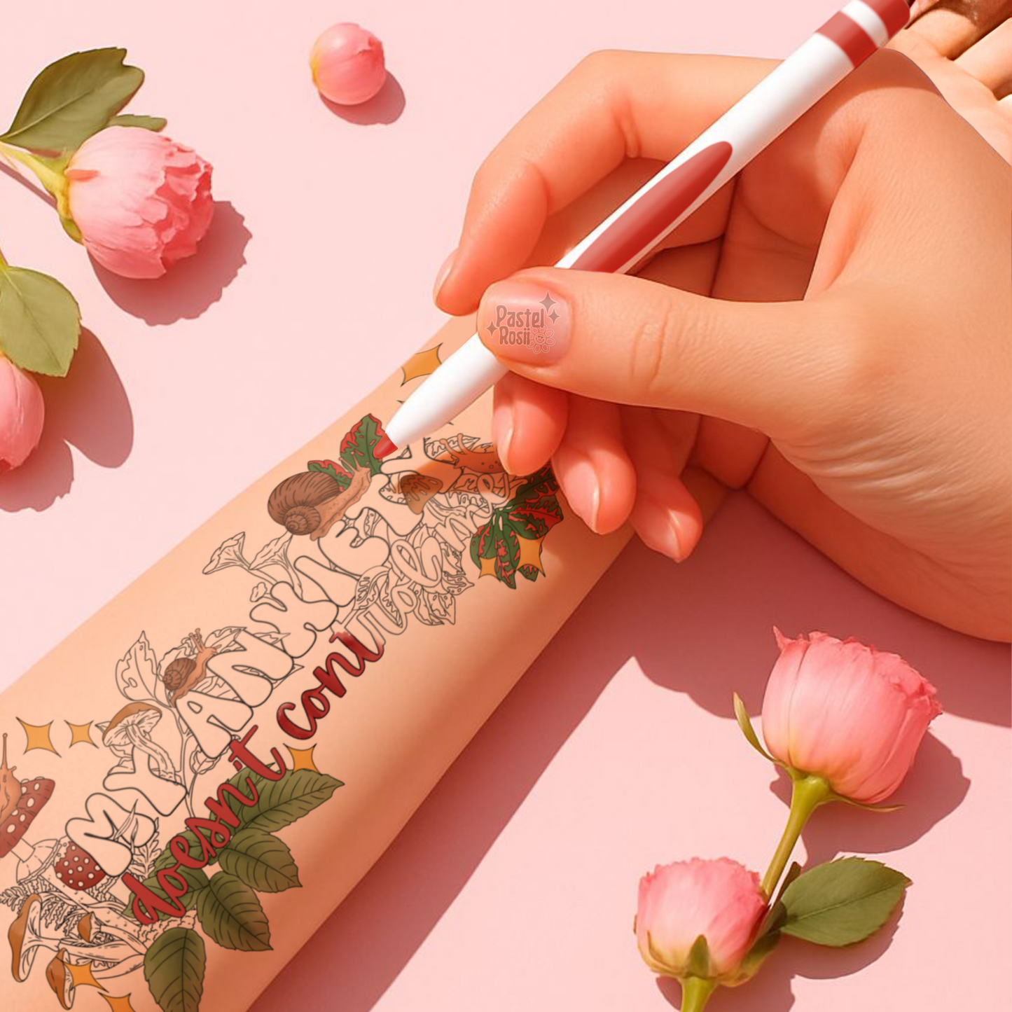 Hand holding a pink pen with floral design on a pink background