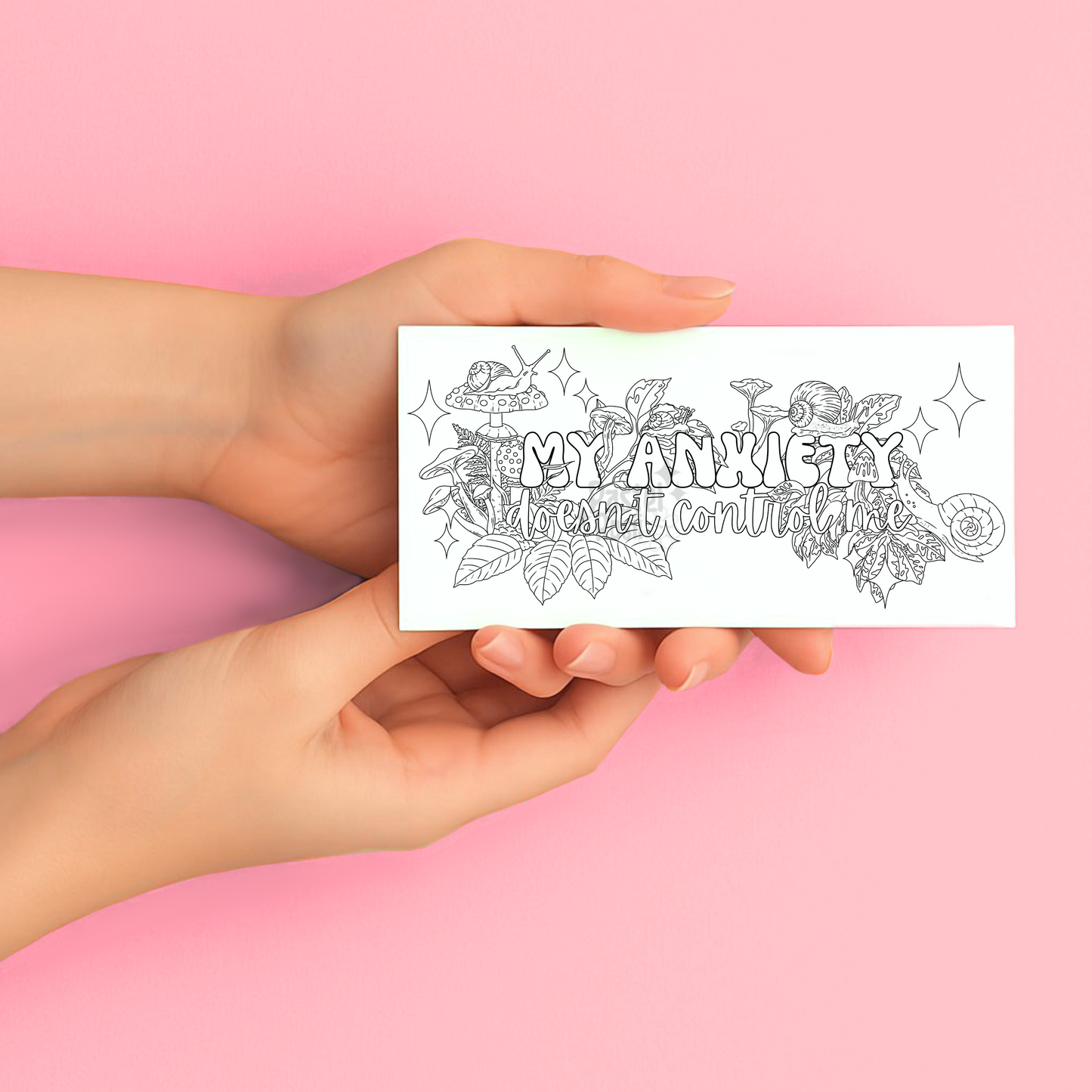Hands holding a coloring temporary tattoo page with floral and text design on a pink background