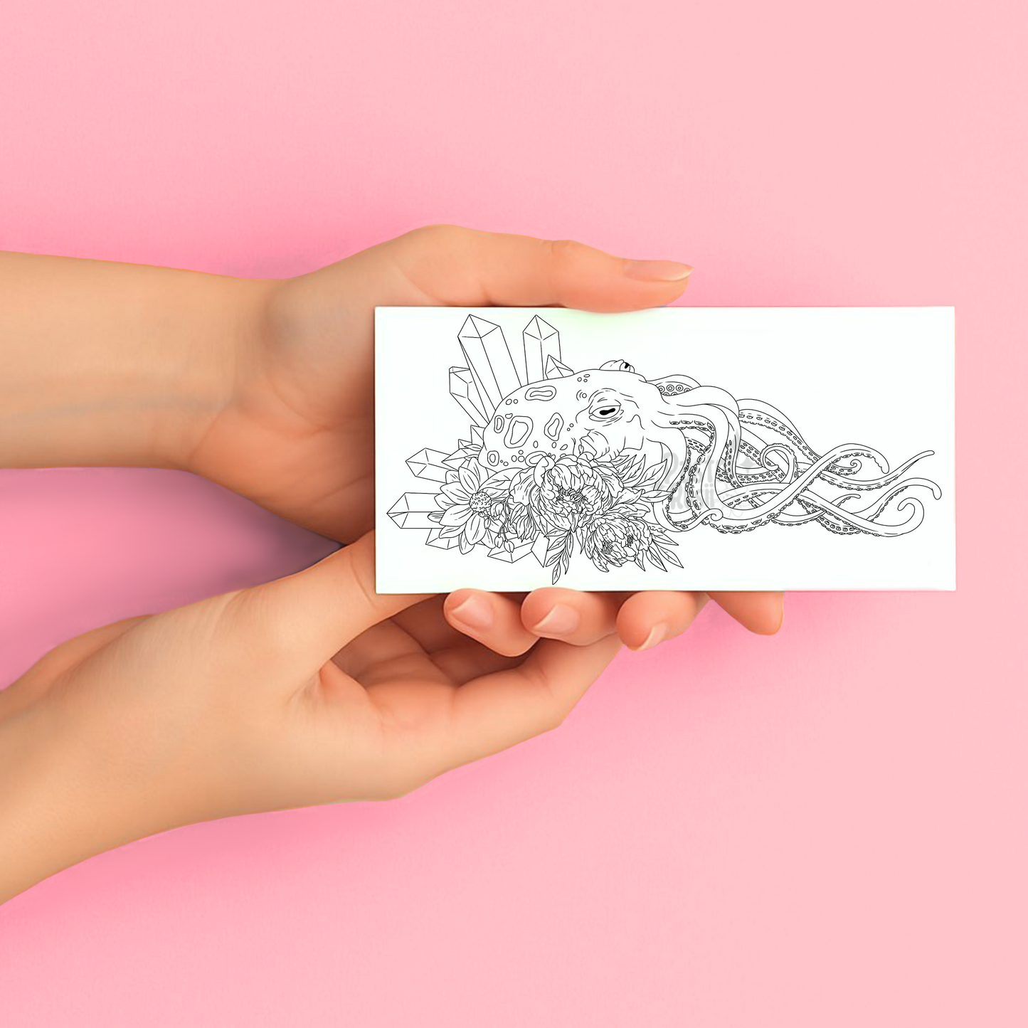Hands holding a temporary tattoo with a black and white octopus design against a pink background