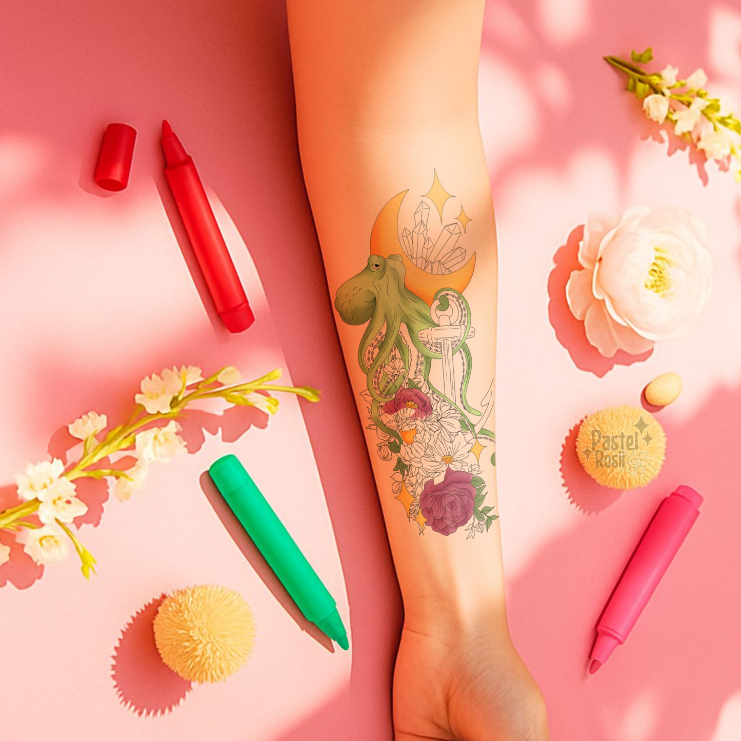 Tattoo of an octopus and flowers on a person's arm with colorful markers and flowers on a pink background.