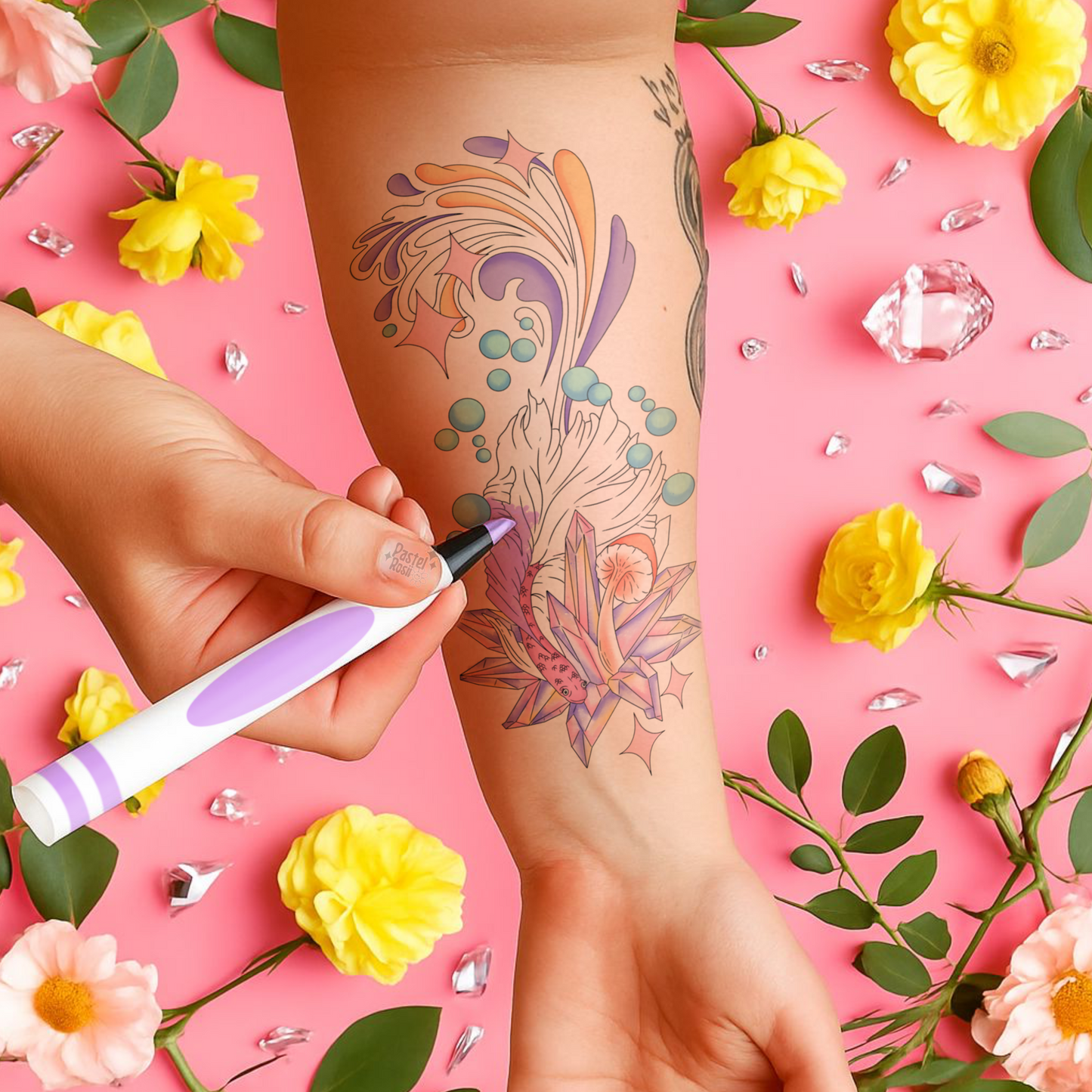 Person getting a floral tattoo on their arm with a pink background featuring flowers and crystals.