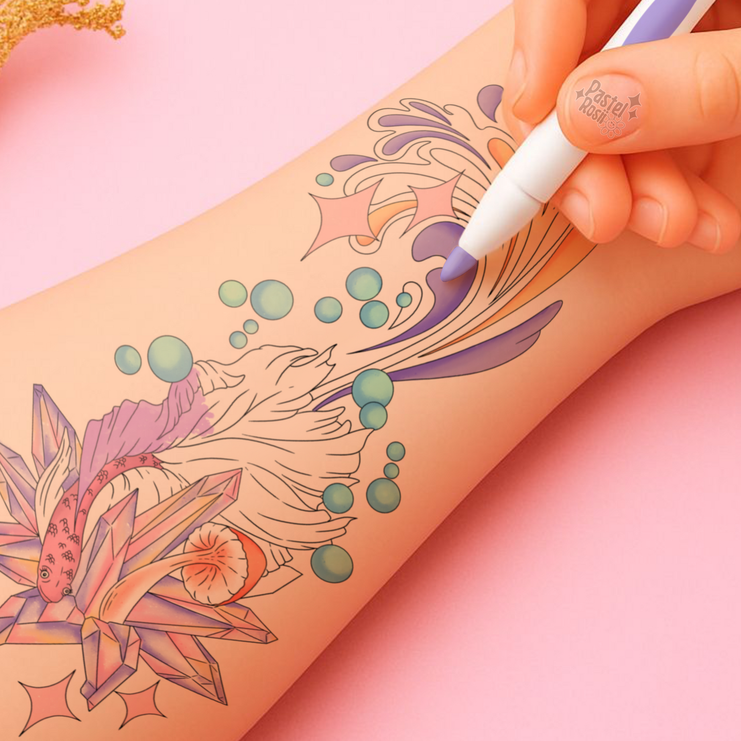 Hand with tattoo pen over a person's arm with a colorful tattoo design on a pink background