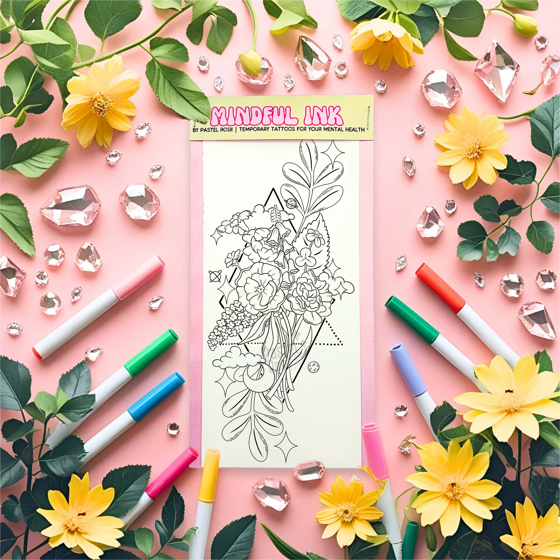 Temporary tattoo with floral design surrounded by markers, flowers, and leaves on a pink background