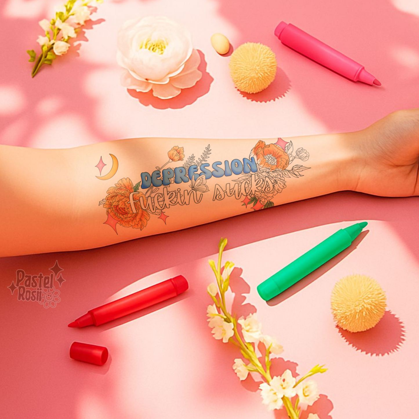Tattoo of 'Depression Fuckin' Sucks' on a arm with colorful markers and flowers on a pink background.